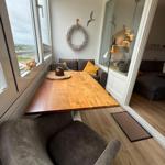 Essbereich mit Holztisch, Sitzgelegenheit und Blick aus dem Fenster.