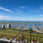 Blick auf Hafen mit Booten und Meer unter blauem Himmel