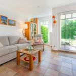 Wohnzimmer mit Sofa, Couchtisch und Blick auf die Terrasse