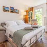 Schlafzimmer mit Doppelbett, Fenster und Tür zum Garten.
