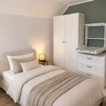 Schlafzimmer mit Bett, Nachttisch, Kleiderschrank und Wickelkommode.