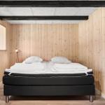 Schlafzimmer mit Holzwänden, Bett und Spiegel