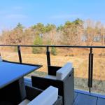 Terrace with seating area and view of forest and meadow.
