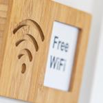 Holzschild mit WLAN-Symbol und Aufkleber Free WiFi.