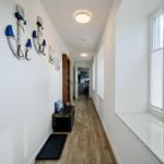 Flur mit Holzboden, Fensterbank und Ankerdekoration an der Wand.