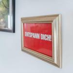 Wall with framed sign RELAX! and pictures