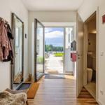 Entrance area with coat rack, mirror, and view of the outdoor terrace.