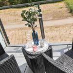 Terrace with two chairs and a table. On it is a vase with plant and candles.