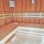 Sauna mit Holzbanken und Temperaturuhr an der Wand.