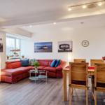 Wohn/Essbereich: Couch und Sessel, TV, Zugang zum Balkon