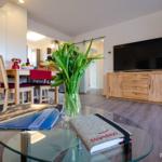 Wohn/Essbereich: Couch und Sessel, TV, Zugang zum Balkon