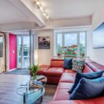 Wohn/Essbereich: Couch und Sessel, TV, Zugang zum Balkon