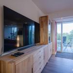 Wohn/Essbereich: Couch und Sessel, TV, Zugang zum Balkon