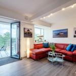Wohn/Essbereich: Couch und Sessel, TV, Zugang zum Balkon