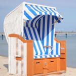 Strandkorb mit blau-weißem Streifenmuster auf Sand