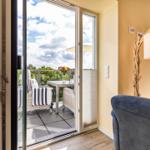 Wohn- und Essbereich: Sofa, TV, Blue Ray Player, Safe, Zugang zum Balkon
