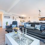 Wohn/Essbereich: Sofa, Sitzbereich, Essbereich, TV, Elektrokamin, Zugang zum Balkon