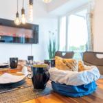 Wohn/Essbereich: Sofa, Sitzbereich, Essbereich, TV, Elektrokamin, Zugang zum Balkon