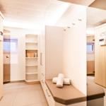 Sauna mit Holzwand, Sitzbank und Regal mit Badartikeln.