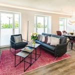 Wohnbereich/Essbereich: Sofa, TV, Beschattungs-Plissess, Treppenaufgang zur Dachterrasse, Zugang zum Balkon