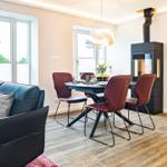 Wohnbereich/Essbereich: Sofa, TV, Beschattungs-Plissess, Treppenaufgang zur Dachterrasse, Zugang zum Balkon