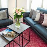 Wohnbereich/Essbereich: Sofa, TV, Beschattungs-Plissess, Treppenaufgang zur Dachterrasse, Zugang zum Balkon