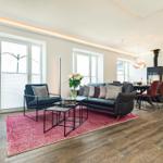 Wohnbereich/Essbereich: Sofa, TV, Beschattungs-Plissess, Treppenaufgang zur Dachterrasse, Zugang zum Balkon