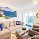 Wohn-/Essbereich: Sofa, Smart-TV, Essbereich, Treppenaufgang zur Dachterrasse, Zugang zum Balkon