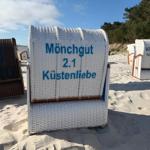 Strandkorb mit Aufschrift Mönchgut 2.1 Küstenliebe auf Sandstrand