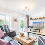 Wohnzimmer: Sofa, 2 Sessel, TV, Zugang zum Balkon