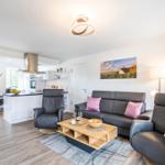 Wohnzimmer: Sofa, 2 Sessel, TV, Zugang zum Balkon