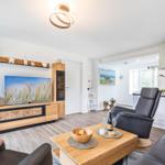 Wohnzimmer: Sofa, 2 Sessel, TV, Zugang zum Balkon