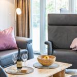 Wohnzimmer: Sofa, 2 Sessel, TV, Zugang zum Balkon