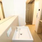 Badezimmer mit Waschbecken, Spiegel und Dusche