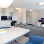 Wohn- und Essbereich mit Küchenzeile, Sofa und Fernseher.