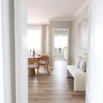 Wohnung mit Essbereich, Sofa und Wandbild. Holzboden und helle Wände.