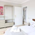 Schlafzimmer mit Bett, Kleiderschrank und Wandbild.