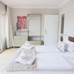 Schlafzimmer mit Bett, Kleiderschrank und Fenster zur Terrasse.