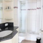 Badezimmer mit Dusche, Waschbecken und Toilette.