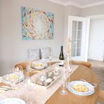 Rundes Esszimmer mit Tisch, Stühlen und Wandbild