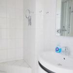 Bathroom with shower, sink, and mirror.