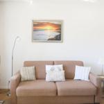 A sofa with cushions, wall art, and a floor lamp in the living room.