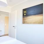 Schlafzimmer mit Bett, Tür und Wandbild mit Bahnübergang.