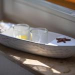 A white boat with two glasses and a starfish on a windowsill.