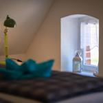 Bedroom with bed, green lamp, and window with lantern.
