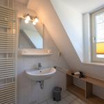Bathroom with sink, mirror, heater, and window with blind.