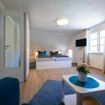 Bedroom with double bed, TV, and window with curtains.