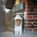 Haus Nordstrand with brick facade, green door, and lantern.