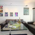 Living room with sofa, glass table, and wall art