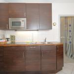 Kitchen with wooden cabinets, microwave, and sink